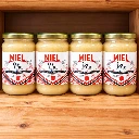 Quatre pots de miel d'été la mare aux abeilles sur étagère en bois.webp
